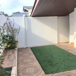 Covered outdoor patio space with garden and privacy wall at PH Las Olas Playa Dorada