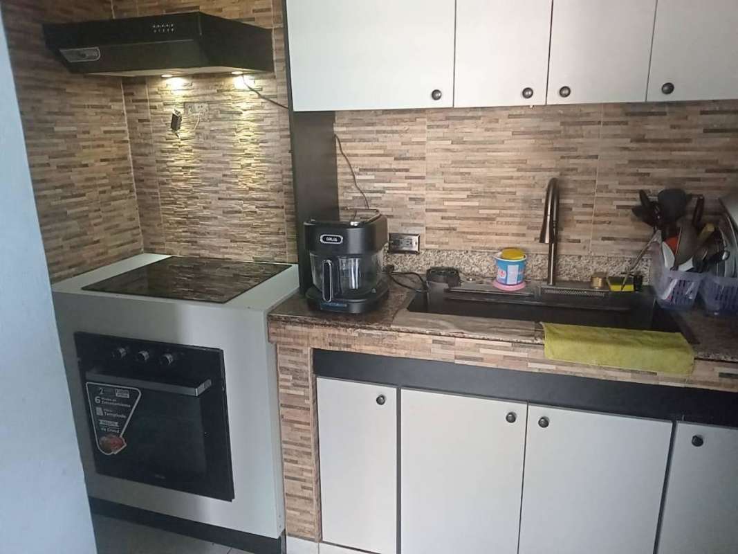 Compact kitchen with granite counters, tile backsplash, stove and cabinets PH Torres de Milán near UTP Panama