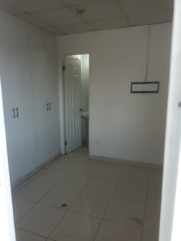 Hallway with two doorways to bathroom and bedroom in Pedregal Rana de Oro apartment