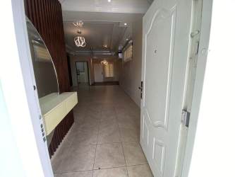 Modern entry hall with accent wood paneling, pendant and recessed lighting at Brisas del Golf House Panama