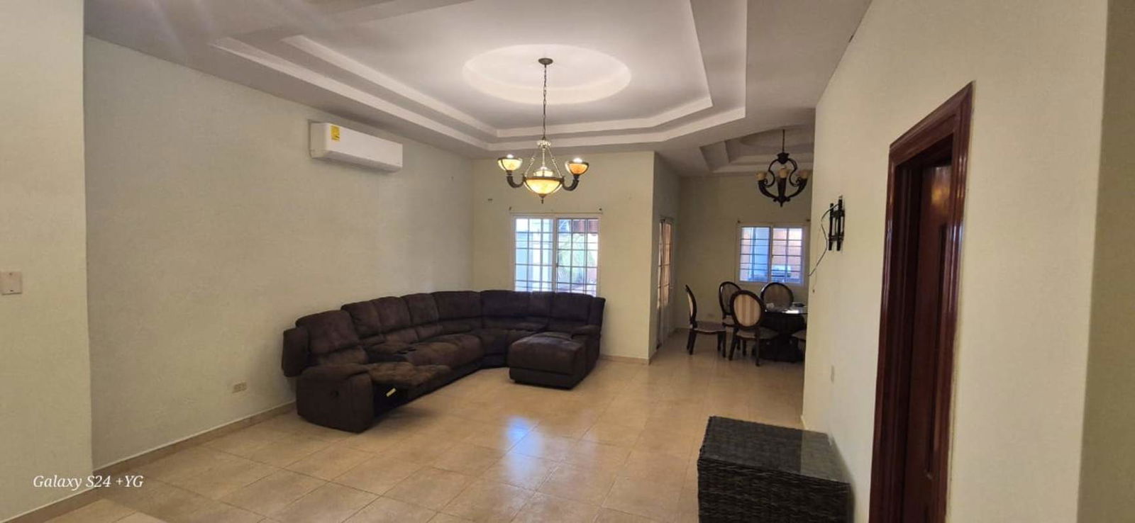 Spacious open-plan living and dining room with chandeliers and tiled floor luxury home Rainforest Village Panama