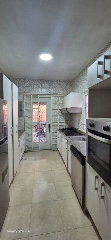 Kitchen with granite counters, built-in oven, stainless appliances, white cabinets Rainforest Village Panama City