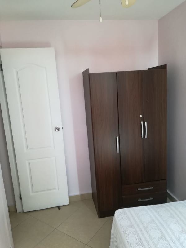 Furnished bedroom with wardrobe, bed, ceiling fan and light pink walls at PH La Cresta near El Carmen Panama City
