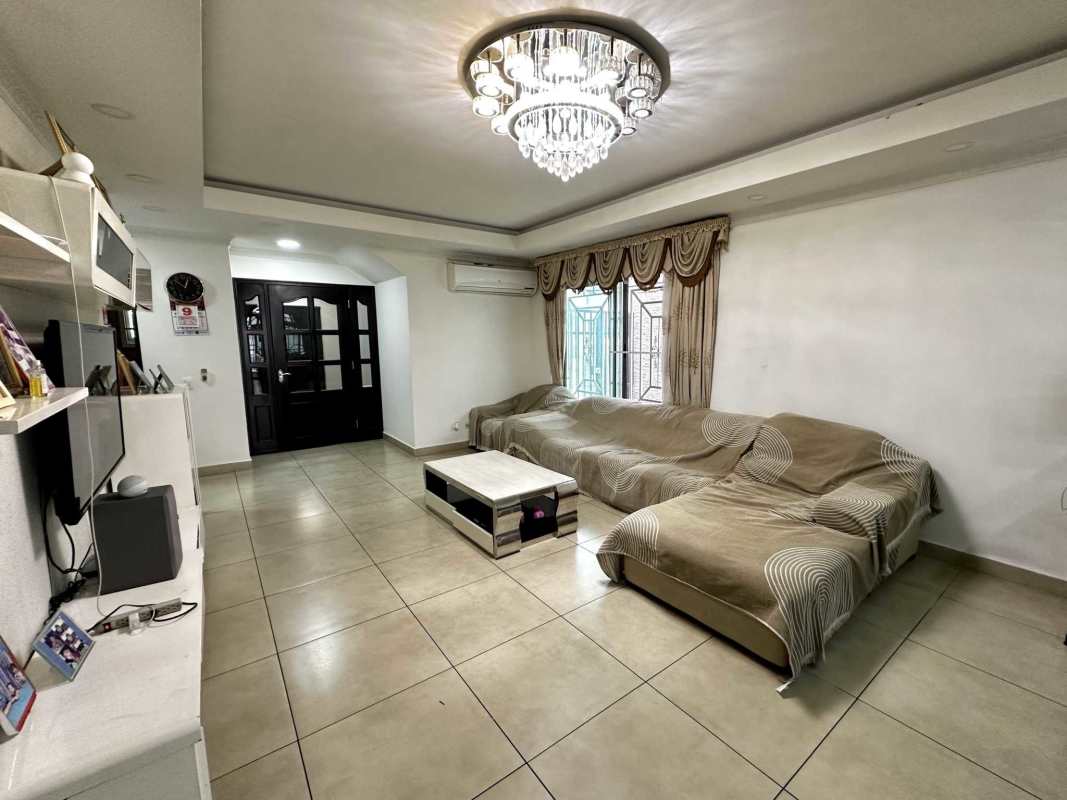 Dining area with chandelier, large table, and patio view at Dorado Village home Condado del Rey Panama City