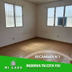 Empty bedroom with white walls, brown tiled floor, barred window in Penonomé Panama