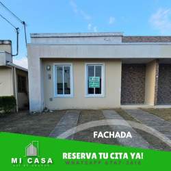 Single-story house with stone accent wall, large windows, driveway and garden