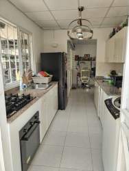 Contemporary kitchen with white cabinets, granite countertop and appliances at Sausalito Gardens Costa Verde Panama