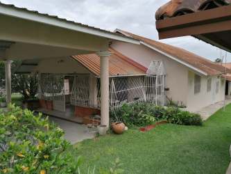 Large fenced yard with lawn and tropical plants surround Alto Boquete rental home