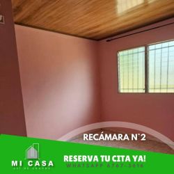 Bedroom with pink walls, wood ceiling, open closet rail and barred window Penonomé