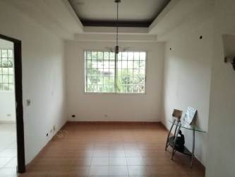 Spacious empty living and dining room with tile floors and large windows in La Chorrera house