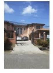 Tile staircase with wooden handrail and black iron railing interior of house in La Chorrera