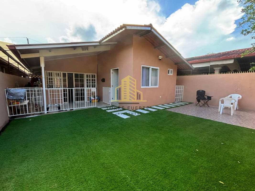 Spacious living room with stone wall accent, mounted TV, and modern decor in Villa Lucre Panama