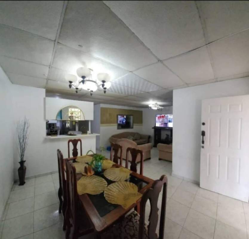 Living and dining area with white walls, ceramic tiled floors, wood dining table and beige sofa set in San Antonio Panama