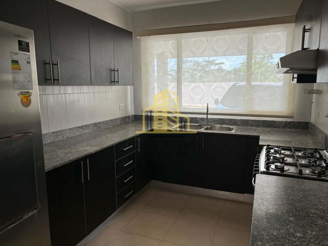 Modern spacious kitchen granite countertops window L-shaped cabinets Brisas del Golf home