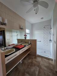Modern bathroom with double vanity, large mirror, walk-in shower in Coronado luxury apartment