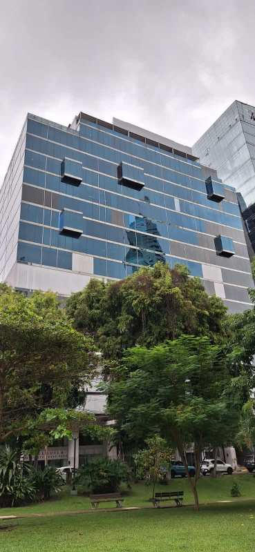 Bright modern office with glass desk and floor-to-ceiling windows city view Panama banking area
