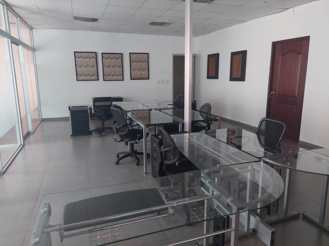 Modern open-plan office area with glass partitions and granite floors Panama City