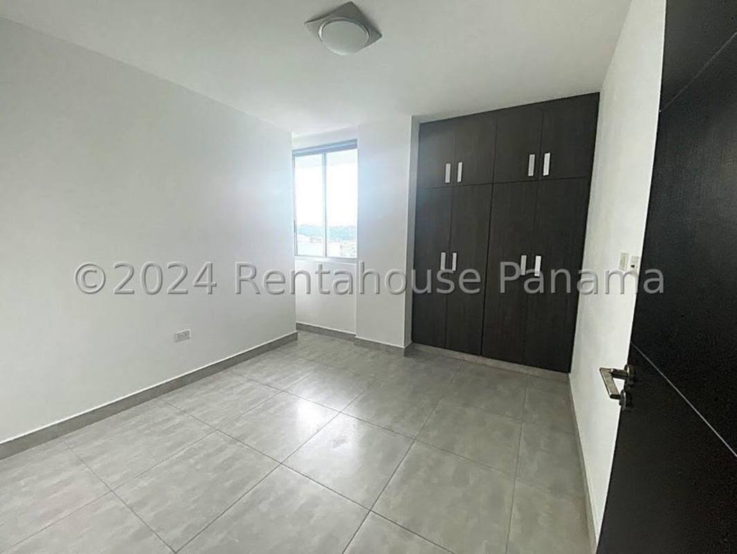 Bedroom with large window overlooking Condado del Rey and greenery PH Condado Gardens Panama