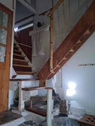 Bright interior dining and living area with wooden stairs leading to mezzanine loft in house at Las Uvas San Carlos Panama