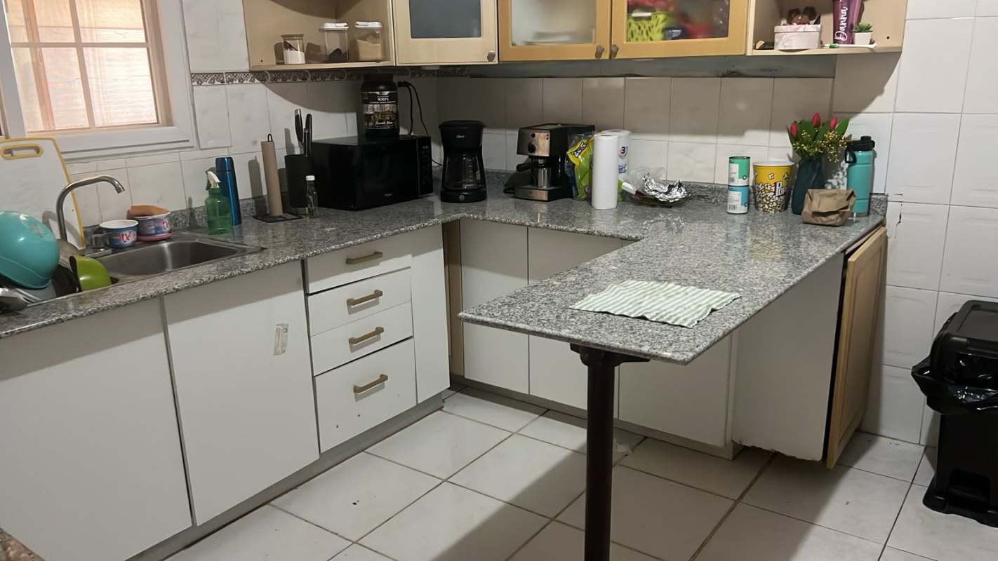 Contemporary kitchen with granite tops white cabinets appliances in Panama City