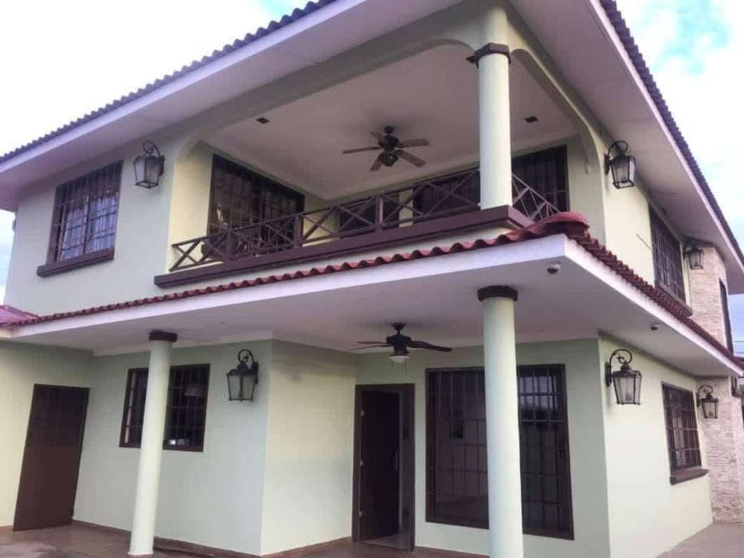 Covered backyard patio with green garden area in corner house at Brisas del Golf Panama City
