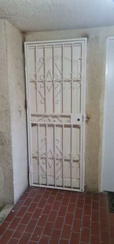 Entrance with secure metal door and brick flooring in apartment in Río Abajo area Panama
