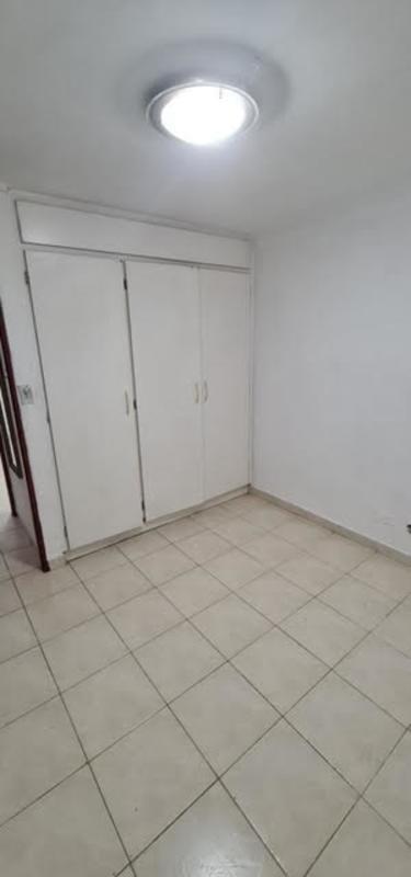 Bedroom featuring ceramic tile floor and built-in closet space in low cost Panama apartment