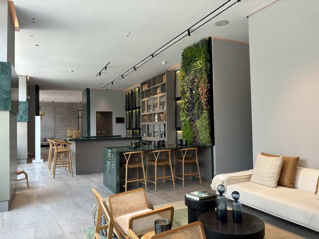 Open concept living room with vertical green wall and modern kitchen bar in Ocean House Santa Maria Panama City