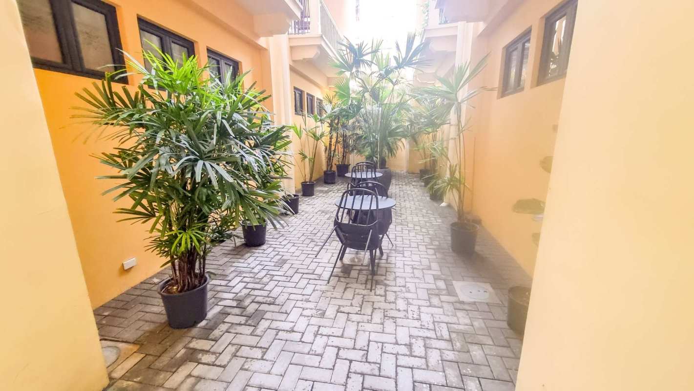Dining area with glass table, white chairs and balcony access PH Casa Balcones Casco Viejo Panama