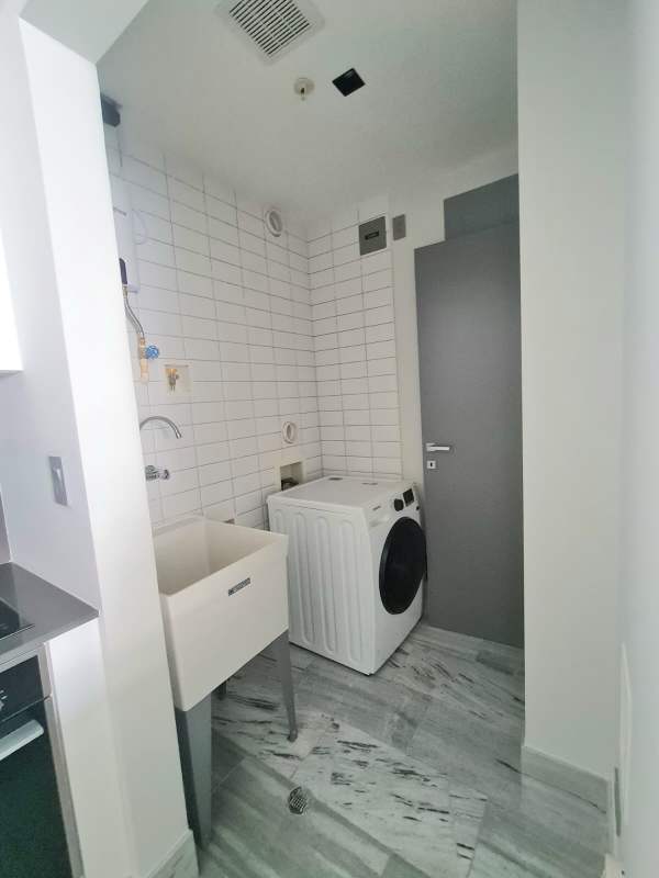 Modern laundry with washer, sink and tile finish in Panama apartment for rent