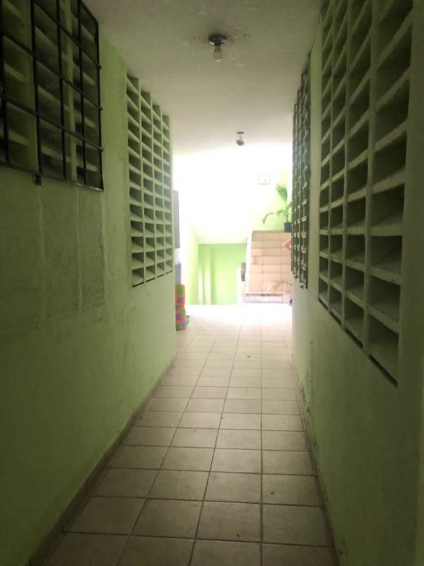 Long corridor in Parque Lefevre apartment building with tile floors and ventilation blocks Panama City