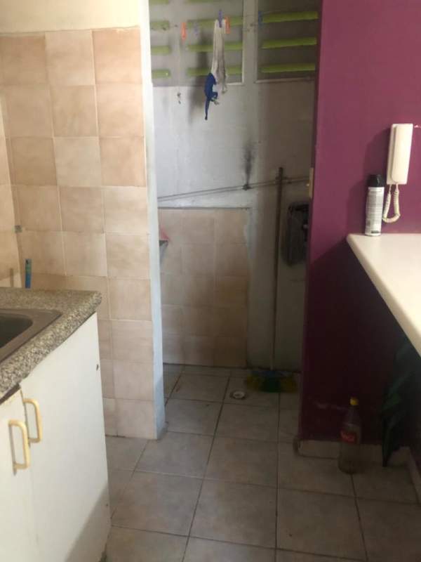 Basic utility space with tiled walls connected to kitchen in studio apartment Parque Lefevre Panama