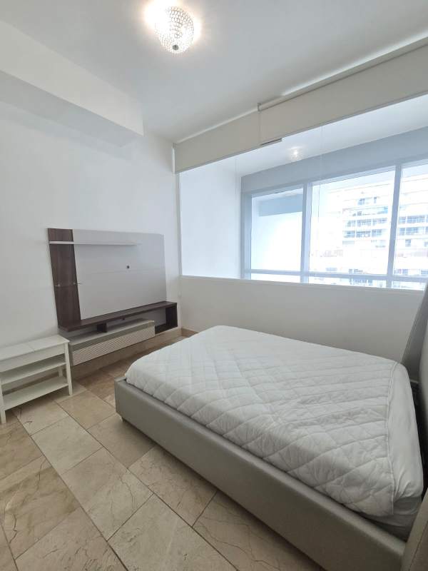 Minimalist bedroom with large window ocean view and city skyline Grand Tower Punta Pacífica Panama