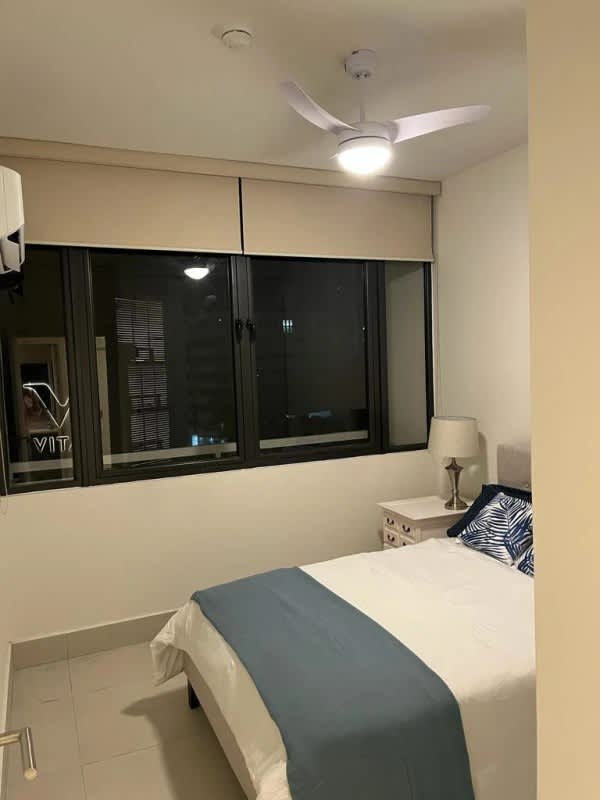 Bedroom with large window, ceiling fan, AC and city views at PH Coco del Mar Panama City