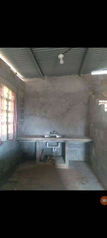 Unfinished kitchen area with cement sink, bare walls, corrugated metal roof Chepo Panama