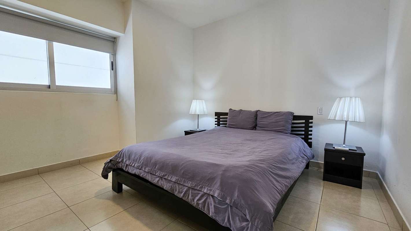 Guest bedroom with city view and large windows in PH Waters On The Bay Panama
