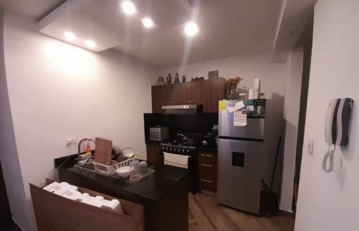 Compact modern apartment kitchen with wood cabinets, granite counter, appliances in PH Liberty Tower