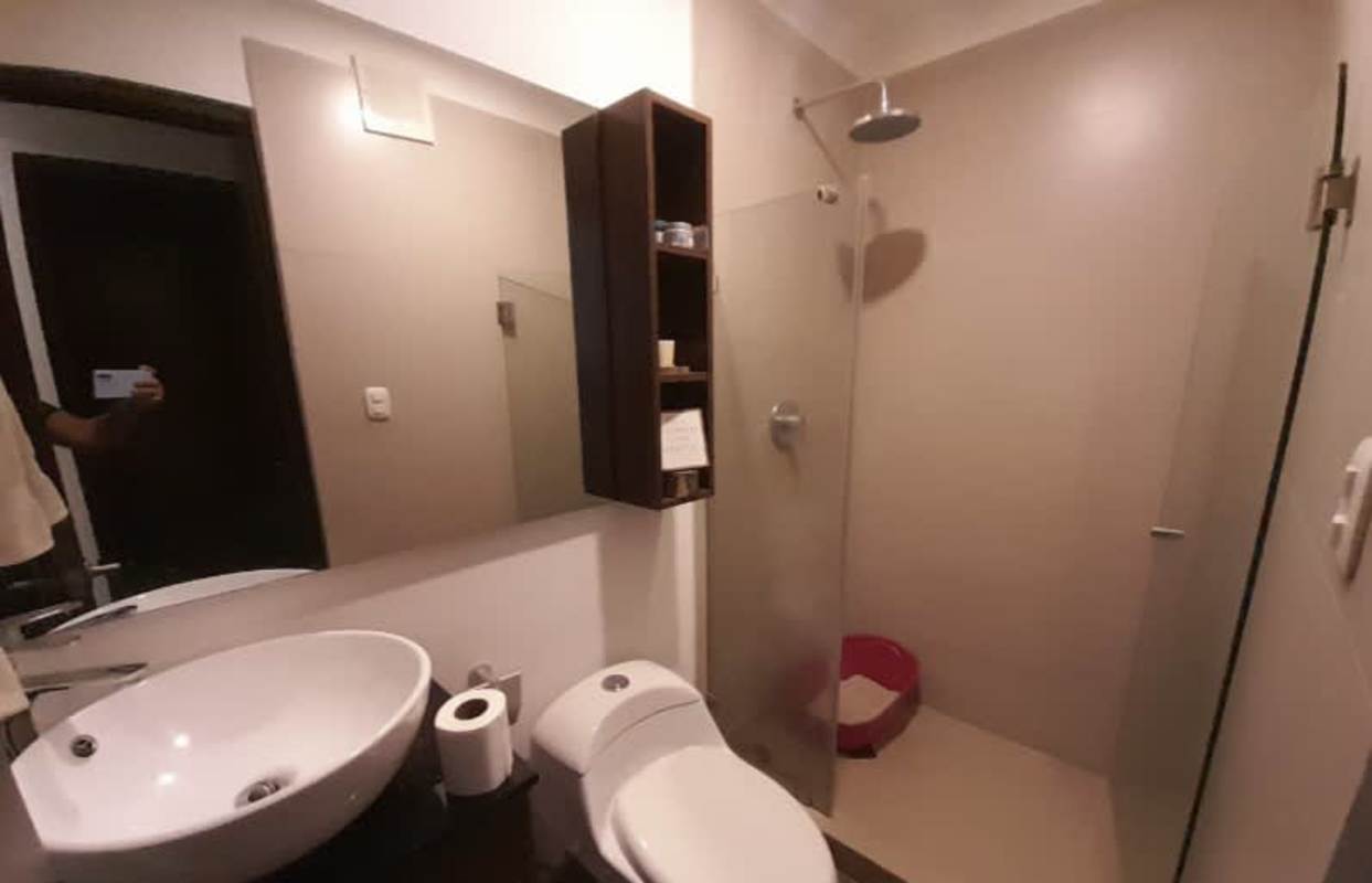 Minimalist bathroom with vessel sink, glass shower, storage in PH Liberty Tower Panama City