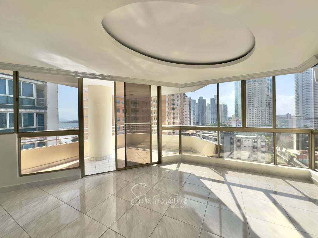 Contemporary living room with marble floors large windows and balcony at PH Avenida Balboa Panama City