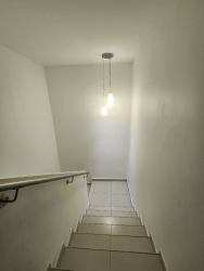 Minimalist indoor staircase with tiles and pendant light in Woodlands duplex Panama Pacifico