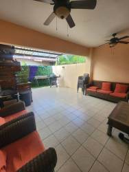 Covered outdoor terrace with garden view and wicker furniture at Woodlands Panama Pacifico