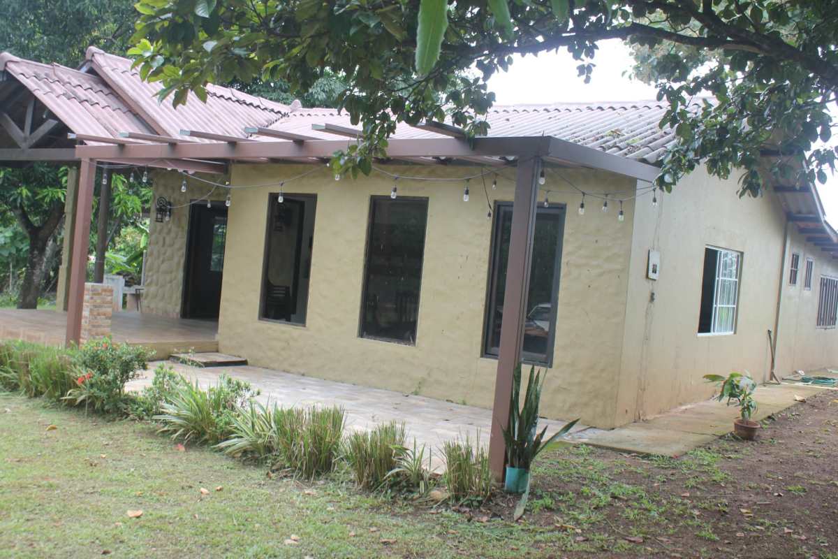 Rustic living and dining area with wood accents and garden views in Pacora Panama house