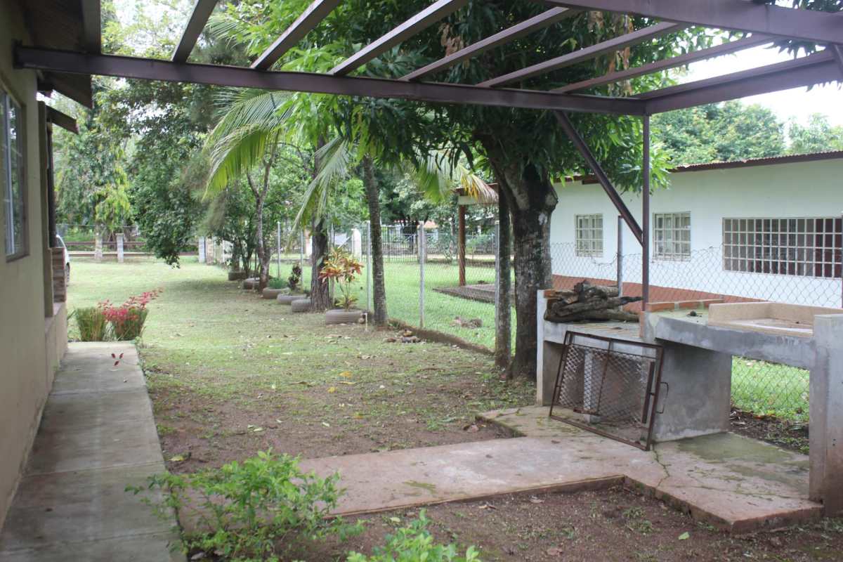 Backyard with open patio, barbecue station, mature trees and garden fence in Pacora Panama