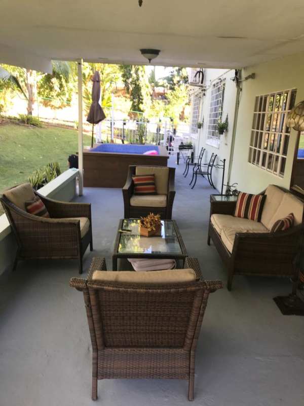 Covered patio with outdoor wicker furniture overlooking garden Diablo Heights