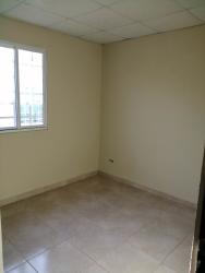 Empty bedroom with neutral walls, tiled floor, window security bars rental Playa Leona