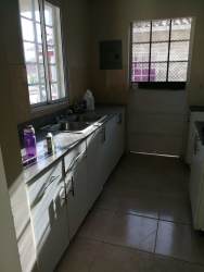 Kitchen with granite counters, white cabinetry, window, door to terrace rental Panama Oeste