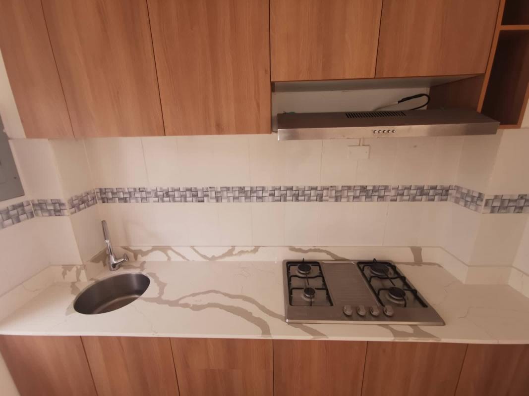 Compact modern kitchen with marble countertop, gas cooktop, wood cabinets Tocumen Panama