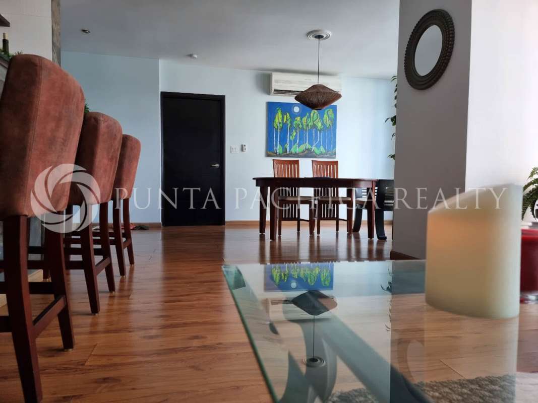 Living room open to kitchen bar with pendant lighting furnished apartment PH Bayfront Avenida Balboa Panama