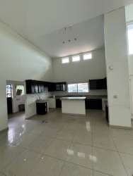 Contemporary kitchen with breakfast counter and cabinetry at Residencial Coquitos Hills house