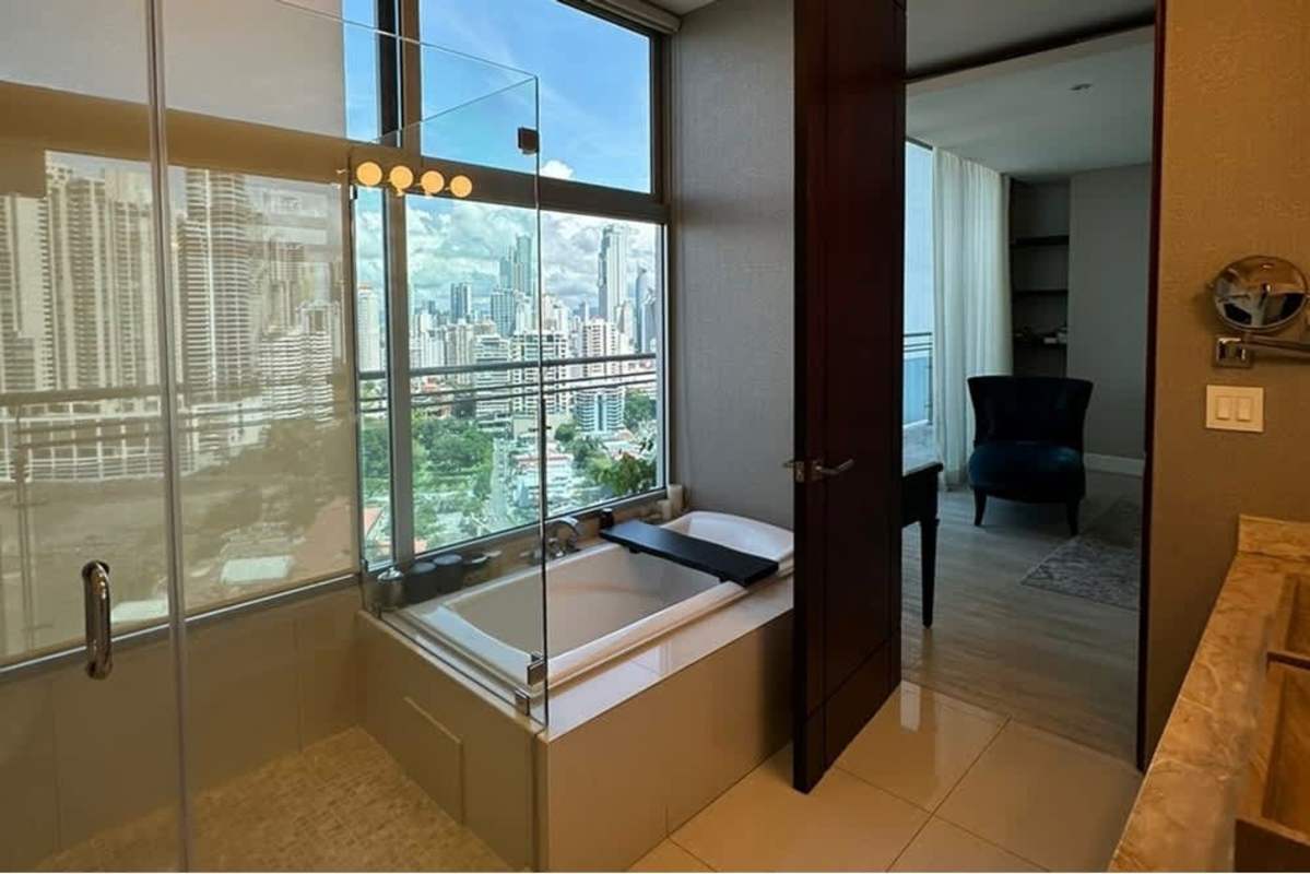 Bright interior lounge with chaise and balcony overlooking ocean PH Ocean Reef Punta Pacifica Panama